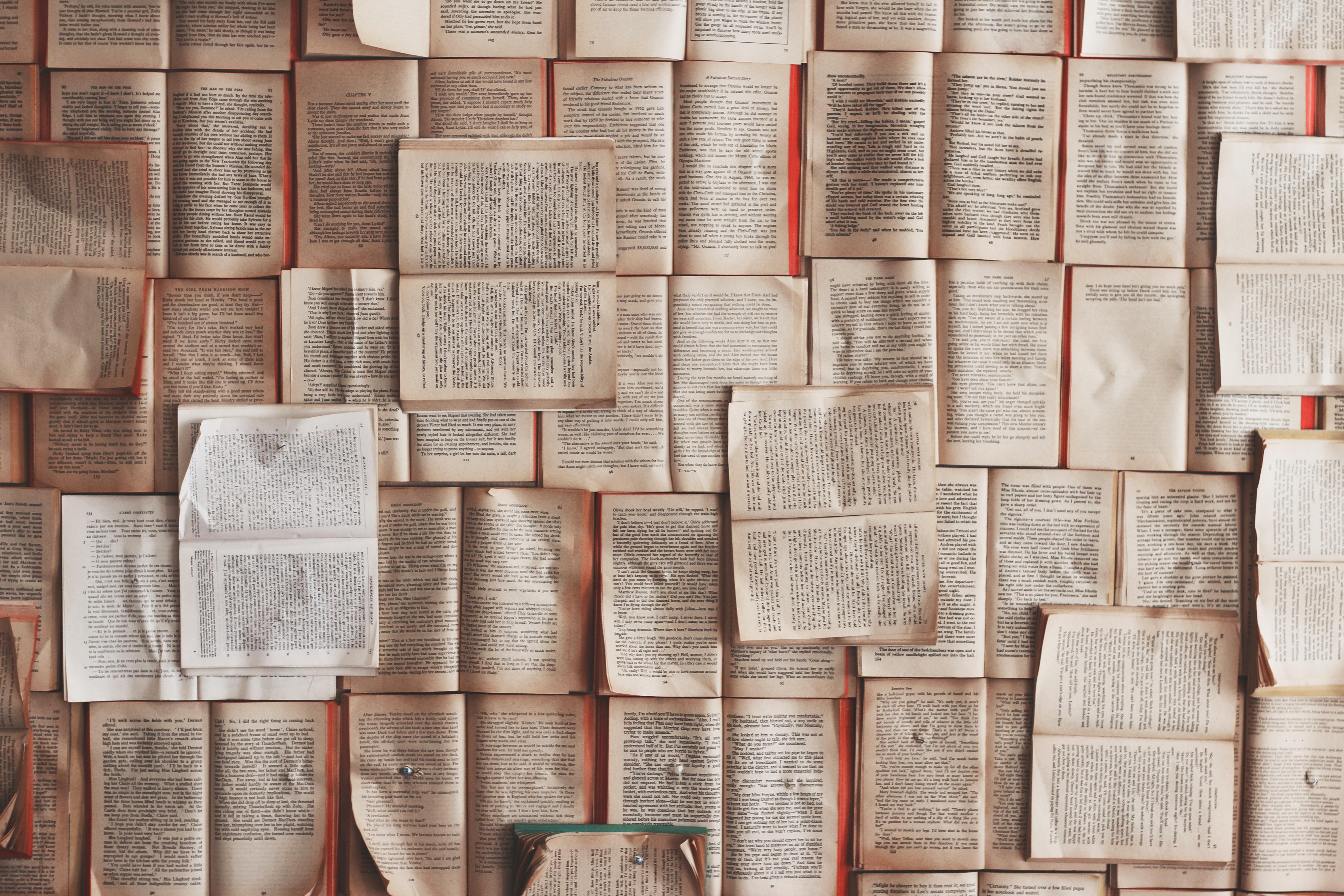 Stack of open books with pages spread out.